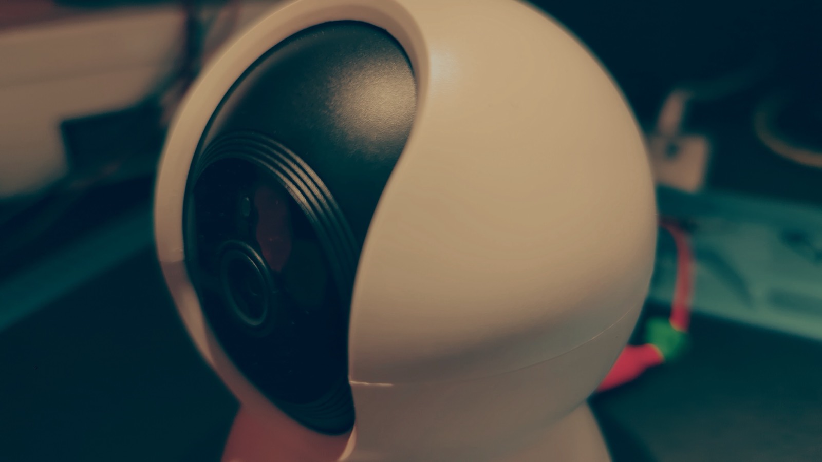 Pan-tilt IP camera on the lab bench, lens facing the viewer, test equipment in the background