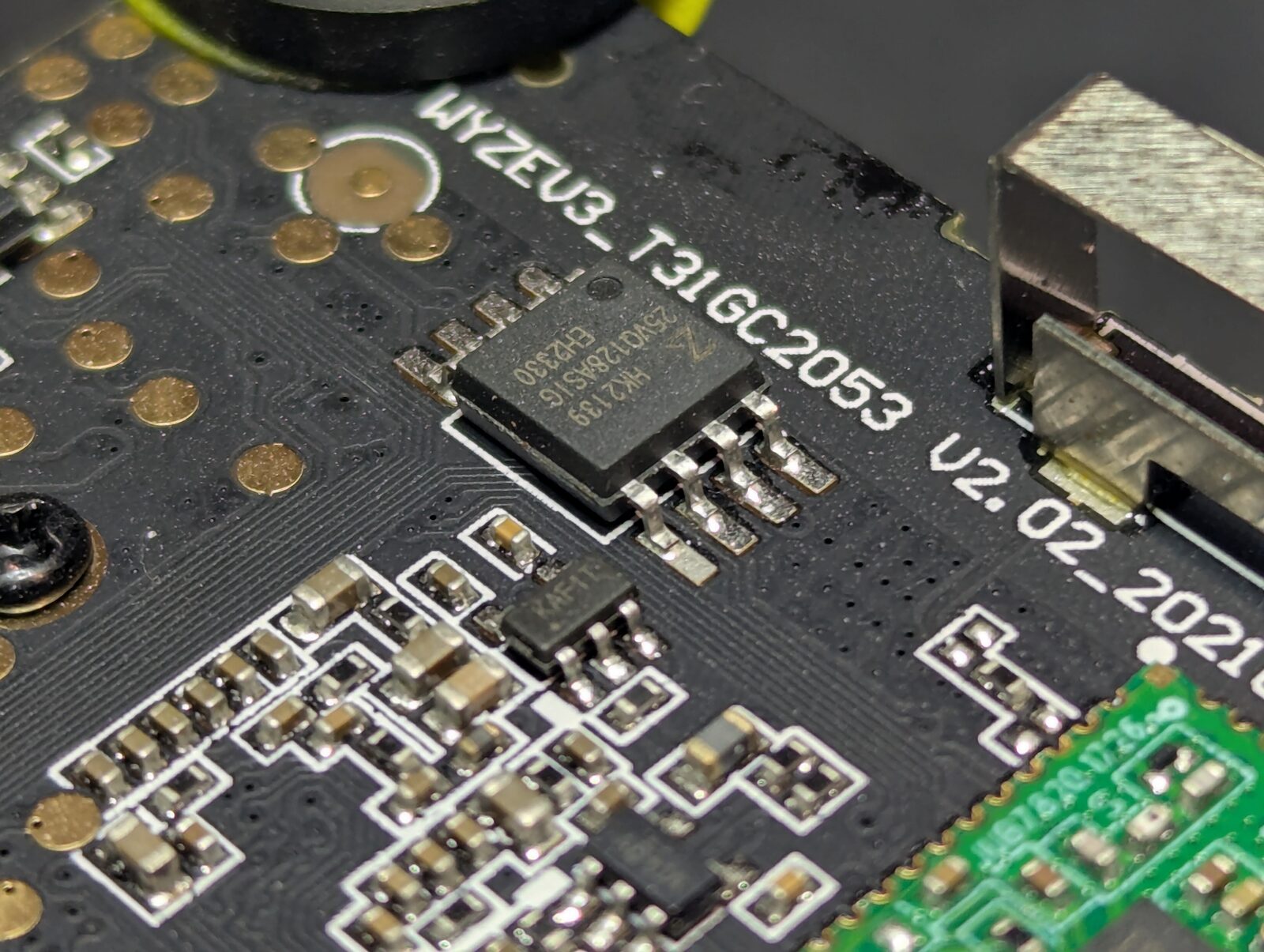 Macro photo of a SOIC-8 SPI flash chip on the board, silkscreen around it reading WYZEV3_T31GC2053 V2.02_2021.